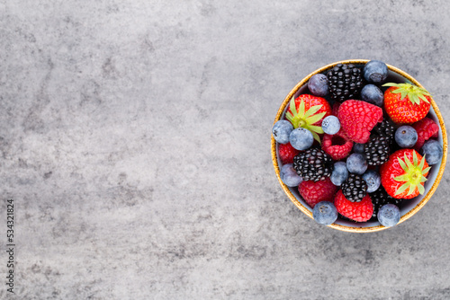 Obraz na płótnie Fresh berry salad on blue dishes. Vintage wooden background. w salonie