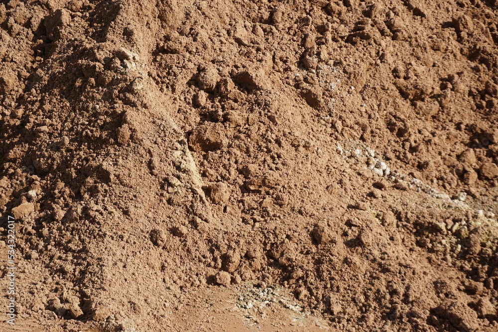 Rot-brauner trockener Erdhügel bei Sonne am Mittag im Sommer