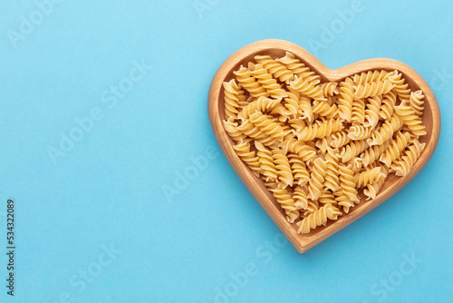 Pasta in a heart shaped wood bowl.