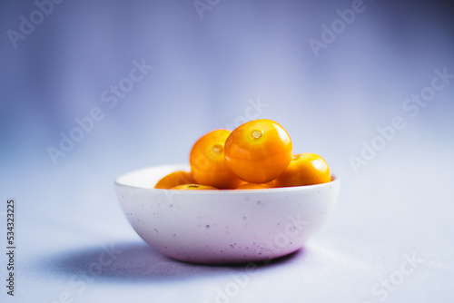 Physalis peruviana fruit berry in a clean background. Ripe physalis berries in the white bowl. photo