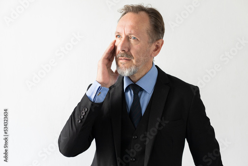 Concentrated mature businessman having remembered something. Senior Caucasian manager wearing three piece suit standing with concentrated expression and touching head. Forgetfulness concept