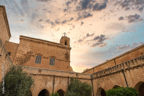 Mor Hananyo Monastery in Mardin Turkey with sunset sky. The famous tourist attraction is also known as Deyrulzafaran Monastery photo