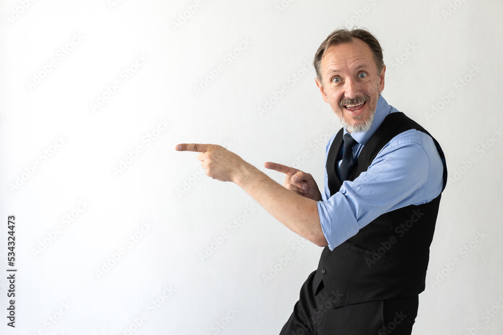 Portrait of excited mature businessman showing something. Senior Caucasian manager wearing formalwear pointing finger and smiling against white background. Advertising concept Portrait of excited mature businessman showing something. Senior Caucasian manager wearing formalwear pointing finger and smiling against white background. Advertising concept