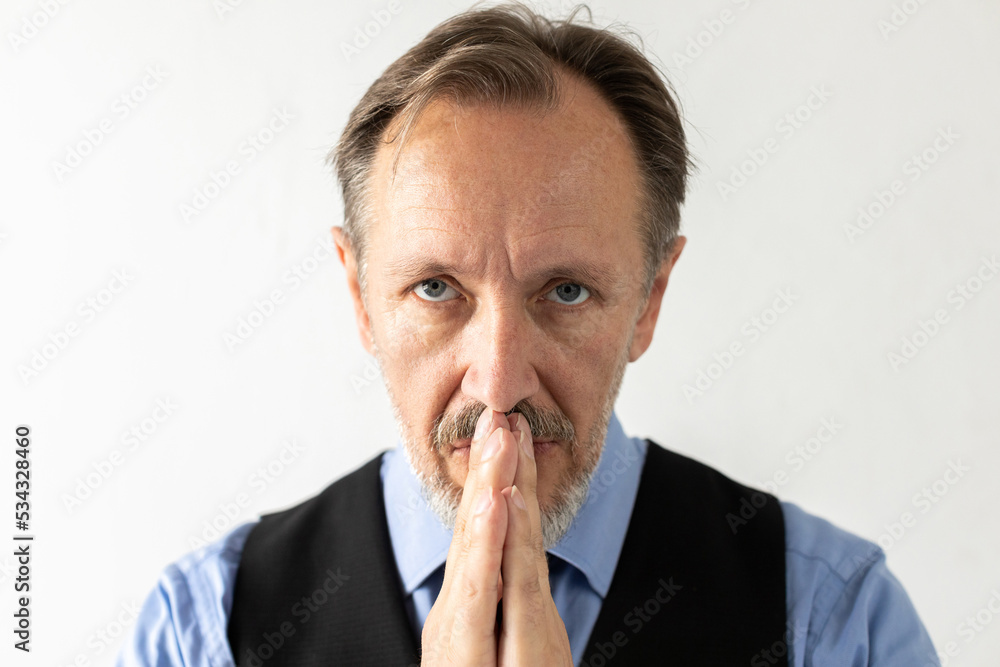 Close-up of serious mature businessman praying. Portrait of senior Caucasian manager wearing formalwear looking at camera and pleading against white background. Hope and faith concept Close-up of serious mature businessman praying. Portrait of senior Caucasian manager wearing formalwear looking at camera and pleading against white background. Hope and faith concept