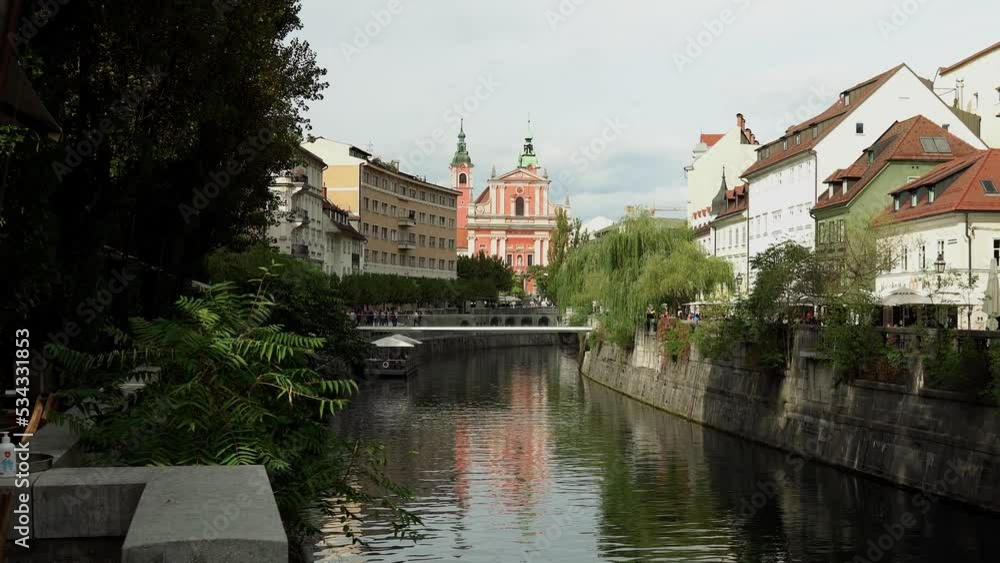 Modern pedestrian bridge Ribja Brv in the center of Ljubljana. Bridge with glass railings over the river Ljubljanica in Ljubljana Slovenia. People walk along the bridge with a beautiful view Modern pedestrian bridge Ribja Brv in the center of Ljubljana. Bridge with glass railings over the river Ljubljanica in Ljubljana Slovenia. People walk along the bridge with a beautiful view