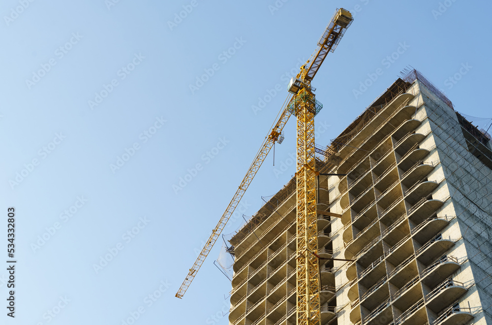 Bottom view of a crane working on the construction of apartments. Bottom view of a crane working on the construction of apartments.