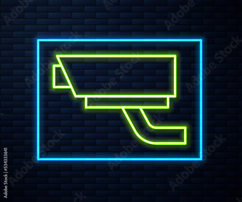 Glowing neon line Security camera icon isolated on brick wall background. Vector