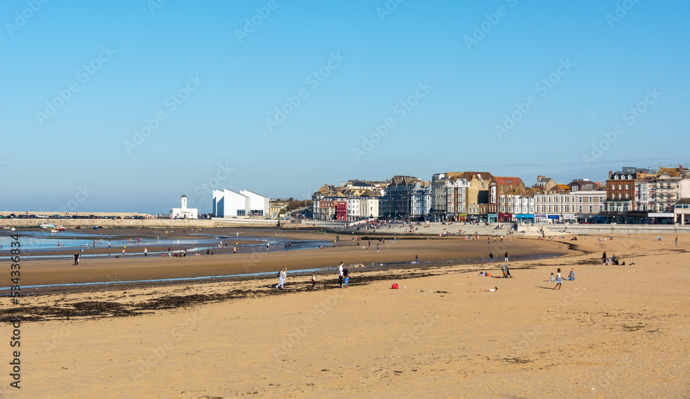 Margate beach during summer holiday, with The Turner contemporary in the background with blue sky.