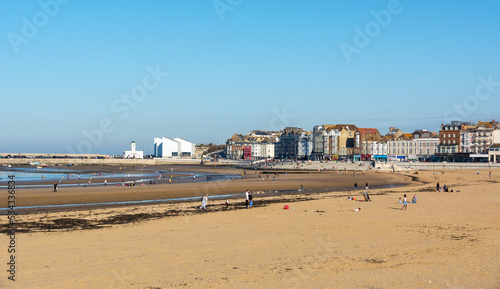 Margate beach during summer holiday, with The Turner contemporary in the background with blue sky.