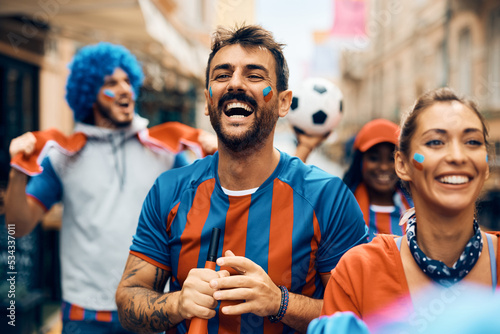 Excited soccer fan going on match with group of his friends during world championship.