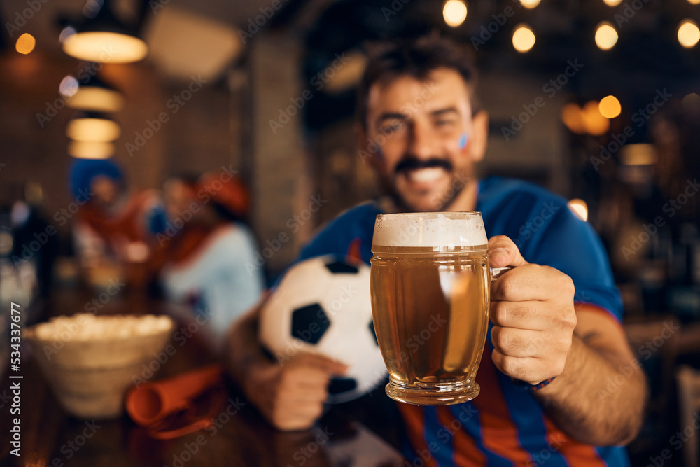 Close up of sports fan toasting with beer during football world cup.