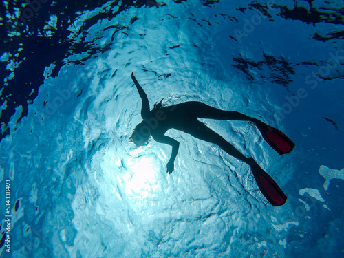 silueta mujer buceando snorkel en el mar azul transparente