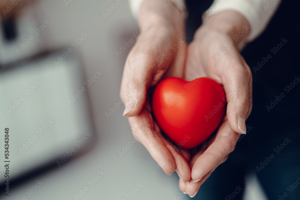 image of a red heart in the palms of a woman.