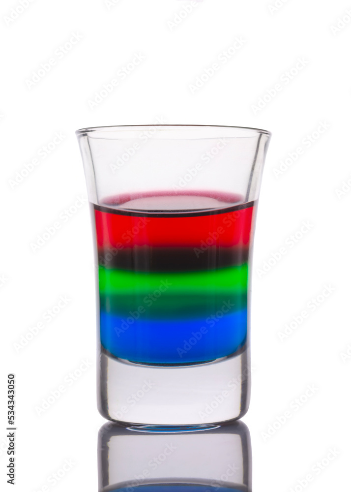 Colored water layers in a shot glass isolated on white background Colored water layers in a shot glass isolated on white background