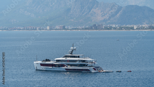 Yacht in the sea against the backdrop of mountains and the city