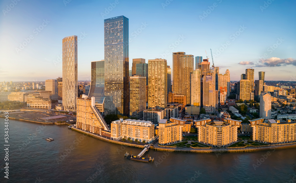 Fototapeta premium Panoramic view of the corporate and residential skyscrapers of Canary Wharf and the Docklands in London, England, during a golden sunset