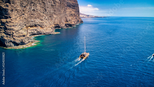 Fotos aéreas de catamarán de recreo en La Playa de Masca y Acantilado de Los Gigantes, Tenerife.