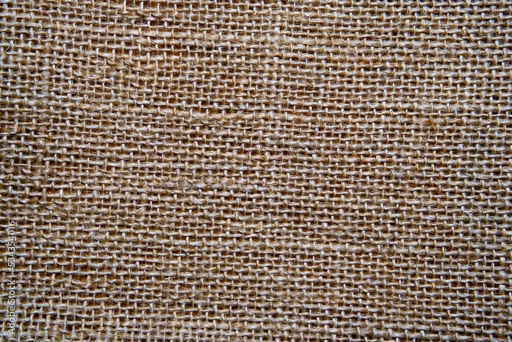 Close-up of coarse plain fabric. Rural style. Abstract burlap background. Space for lettering and design. Selective focus. Close-up of coarse plain fabric. Rural style. Abstract burlap background. Space for lettering and design. Selective focus.