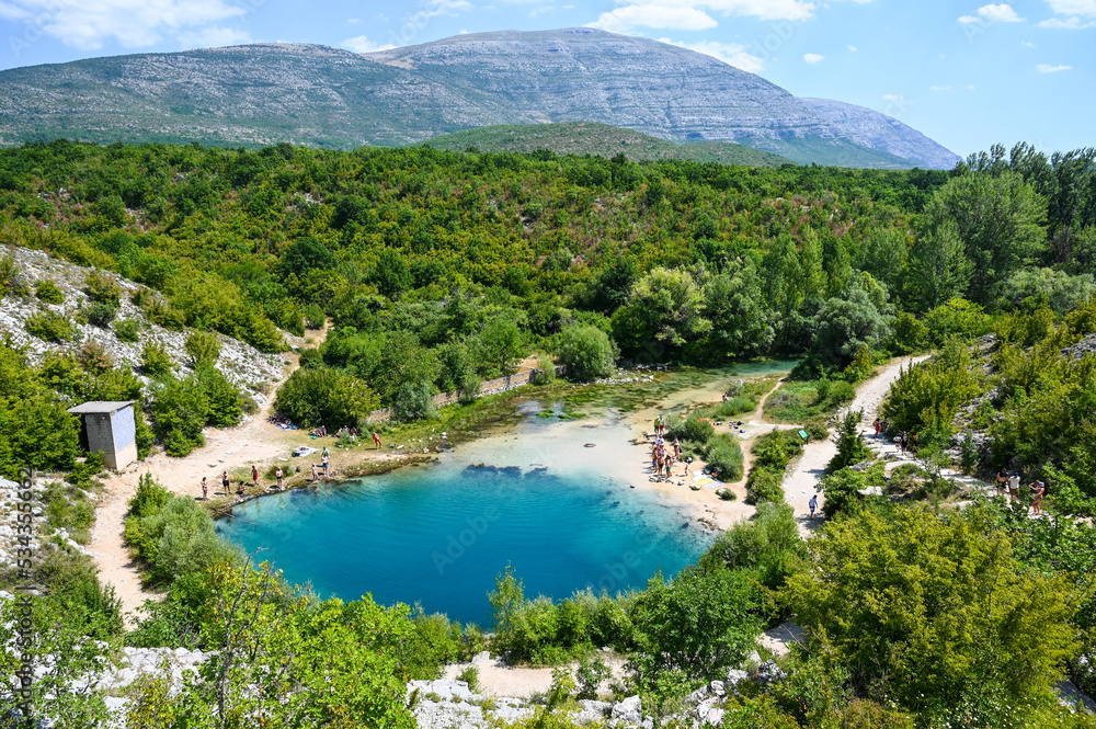 Cetina river source. Deep Karst spring. Nature monument in Dalmatia, Croatia. People swimming in cold water.