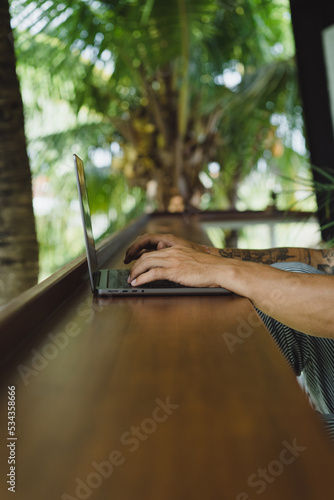 Working on a laptop, maln hands on the keyboard. photo