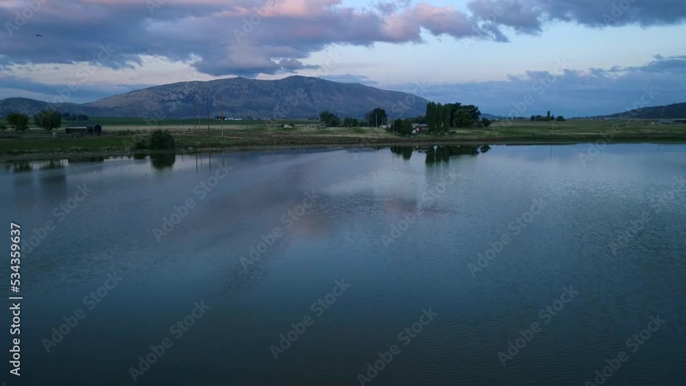 Moving drone shot of a dusk view of a small lake in Klamath Falls, Oregon. Moving drone shot of a dusk view of a small lake in Klamath Falls, Oregon.