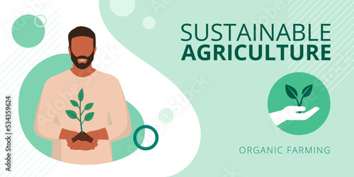 Smiling farmer holding soil and a sprouting plant
