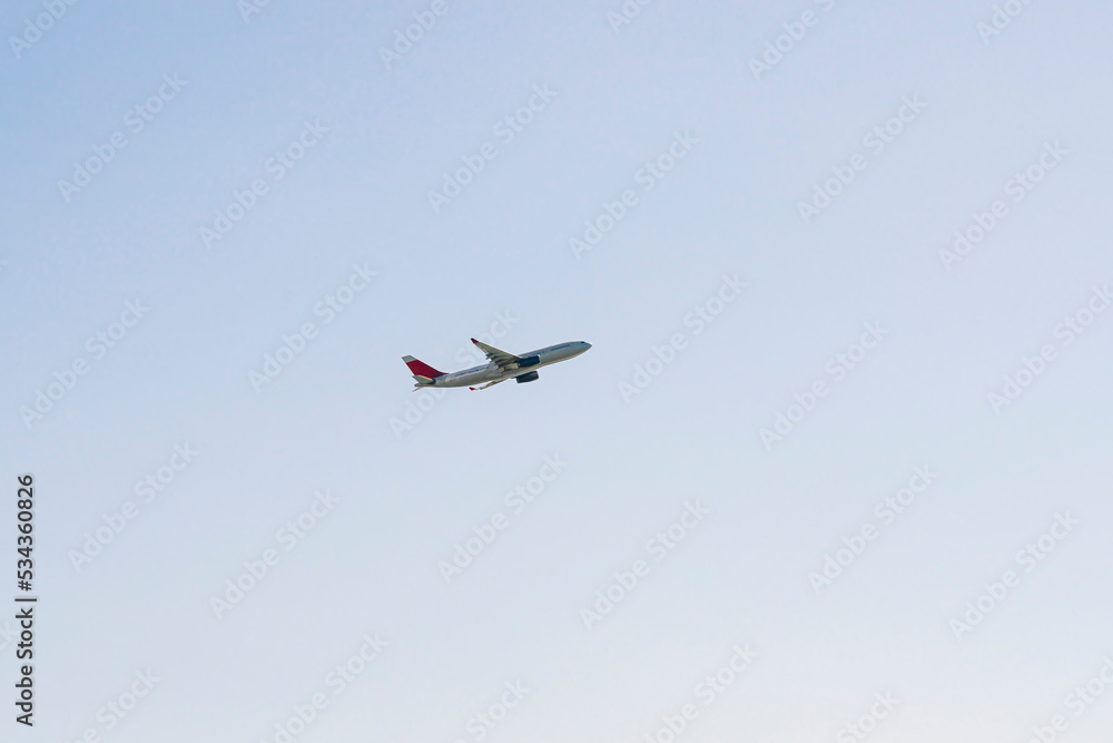 the plane is flying against the blue sky