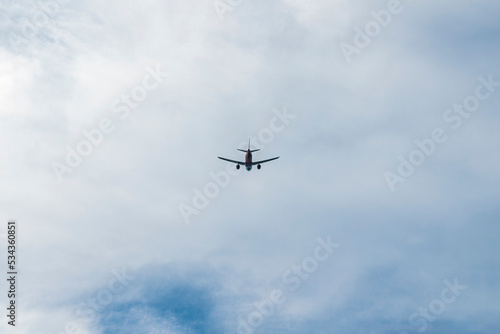the plane is flying against the blue sky