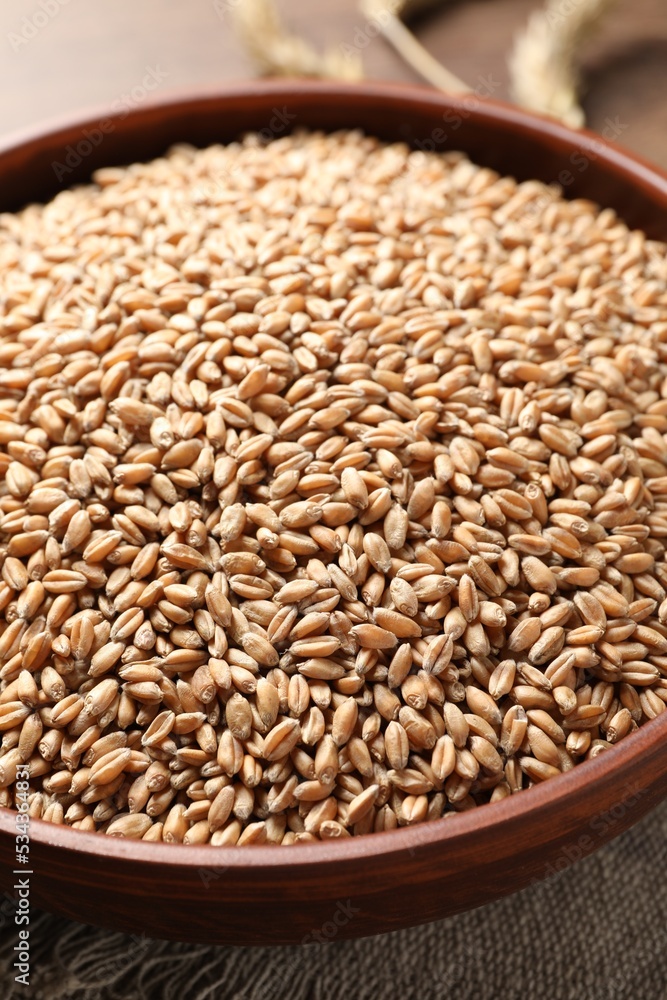 Bowl full of wheat grains on table, closeup Bowl full of wheat grains on table, closeup
