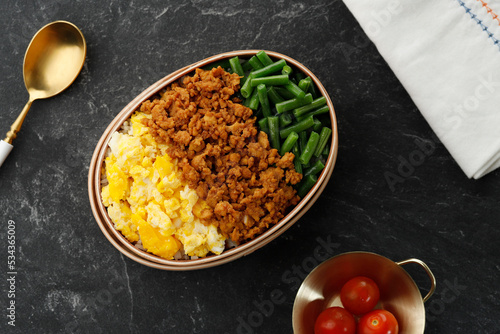 Three Color Japanese Rice Lunchbox with Stir Fry Minced Chicken, Boiled French Beans, and Scramble Eggs. photo