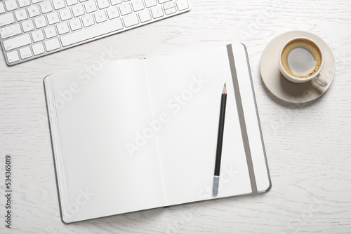 Open blank notebook  pencil  coffee and keyboard on white wooden table  flat lay