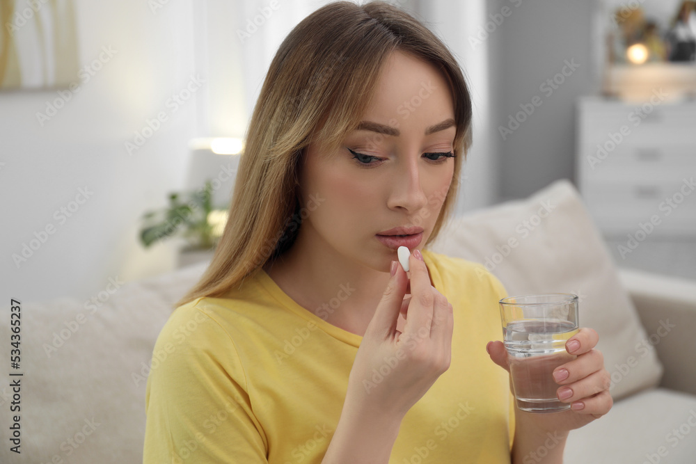 Young woman taking abortion pill at home Young woman taking abortion pill at home