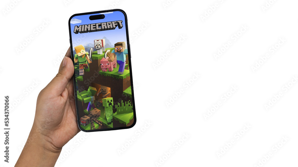 Fototapeta premium Child holding a smartphone iPhone 14 Pro with Minecraft mobile game app on the screen. White background. Rio de Janeiro, RJ, Brazil. September 2022
