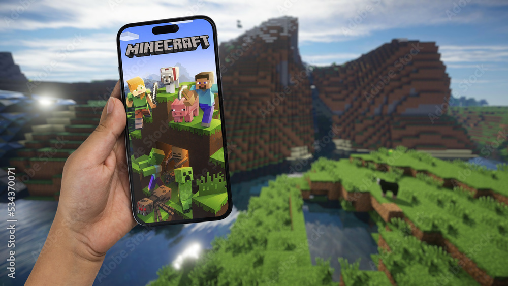 Fototapeta premium Child holding a smartphone iPhone 14 Pro with Minecraft mobile game app on the screen. Website blurred on background. Rio de Janeiro, RJ, Brazil. September 2022