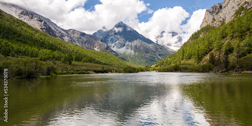 Beautiful panorama view of Yading Nature Reserve in Western Sichuan contains three holy mountains with Milk Lake it is popular for tourists and trekker. Daocheng, Sichuan, China