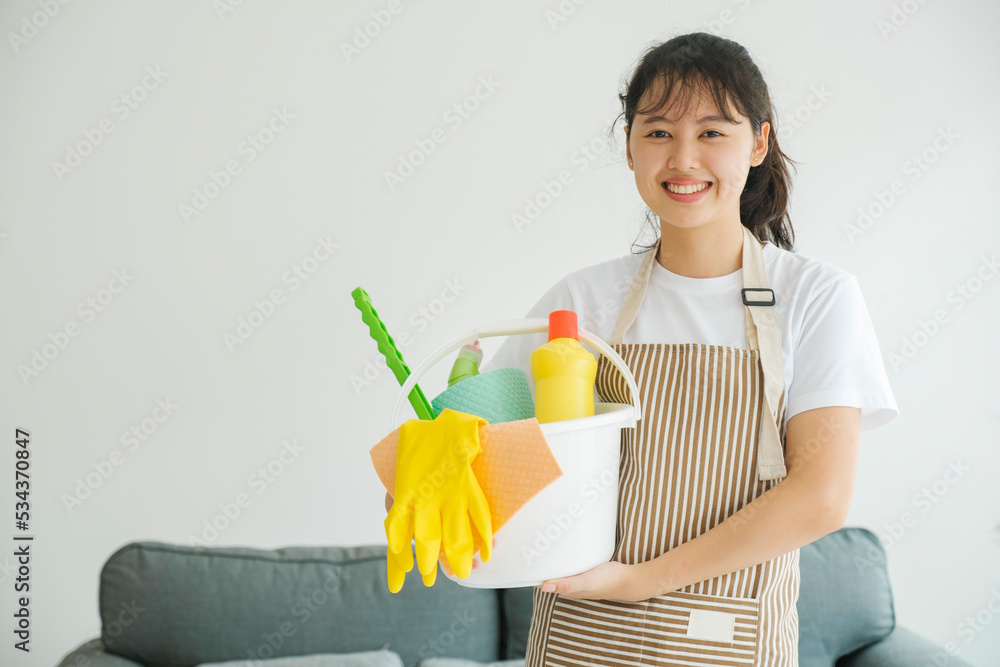 Young woman holding cleaning equipments ready for cleaning. Young woman holding cleaning equipments ready for cleaning.