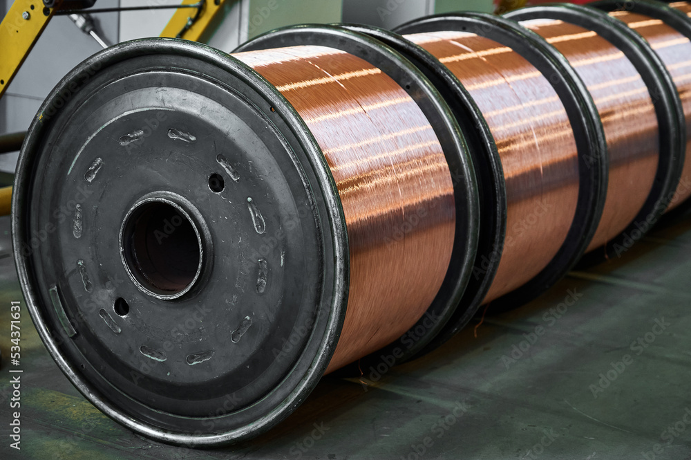 Huge reels with shiny copper wire in factory warehouse Huge reels with shiny copper wire in factory warehouse