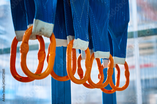 Rigging equipment with textile strops hangs on rack hooks photo