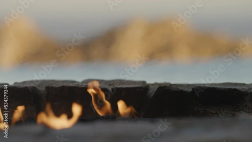 Close up fire pit with blurred background of infinity pool and Cabo mountain at sunset photo