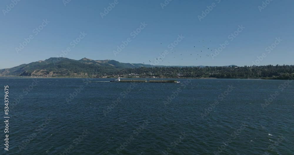 Drone aerial of a barge traveling down the Columbia River Gorge. Shot on Mavic 3 Cine. 30 fps. 4k resolution. Prores. Drone aerial of a barge traveling down the Columbia River Gorge. Shot on Mavic 3 Cine. 30 fps. 4k resolution. Prores.