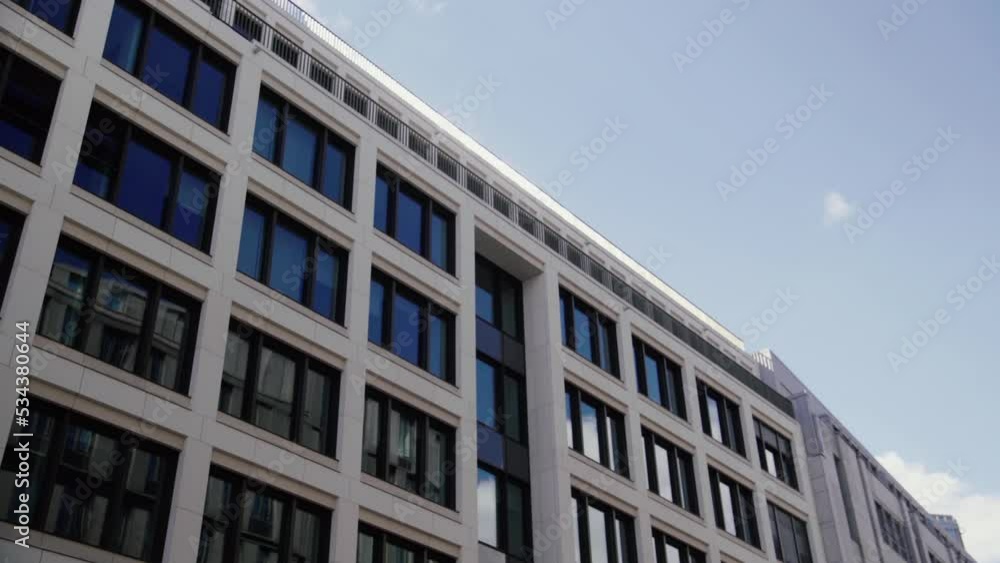 Glass Front of Office Building against the blue sky. 4K. Looking Up. Europe Glass Front of Office Building against the blue sky. 4K. Looking Up. Europe
