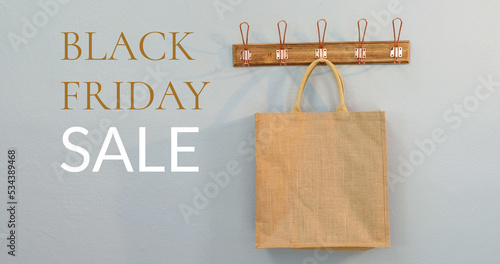 Composition of black friday sale text over brown shopping bag in background