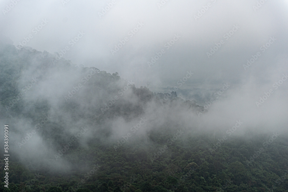 Mountain range with visible silhouettes through the morning colorful fog. Mountain range with visible silhouettes through the morning colorful fog.