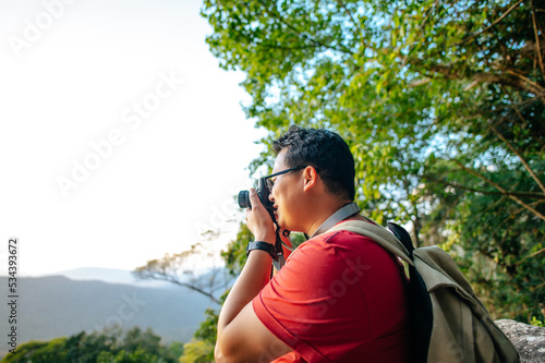 Young trekking man use camera photograph beautiful view