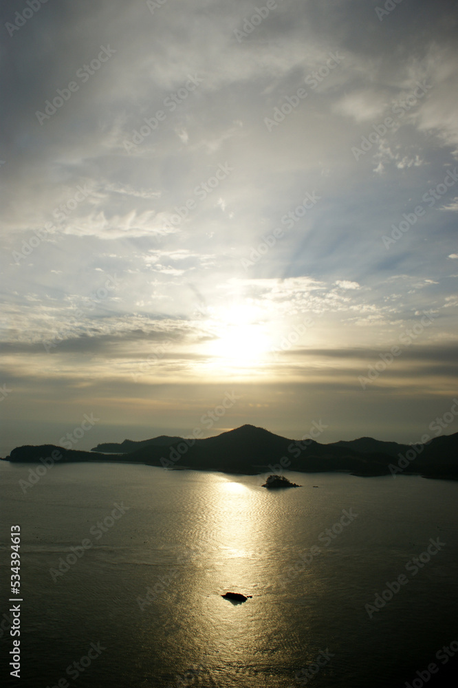 The sky and sea are colored golden at sunset