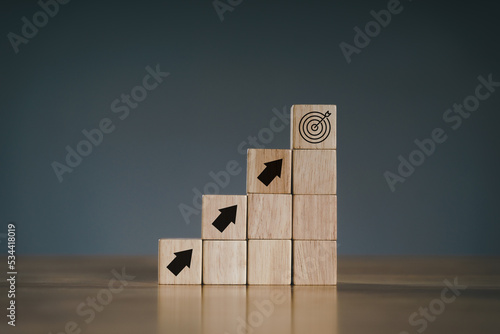 Pile of wooden cube block stack as stair step on wood table. Success, climbing to the top, Progression, business growth concept.