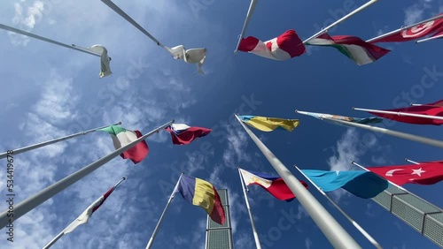 Flags of the World waving in the wind on a background blue sky and white clouds. flags of many countries.  for political, international trade, relationship concepts