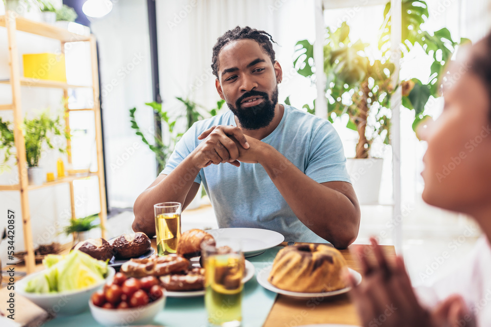 A multi-generational African-American family enjoying food at their dinner table. A multi-generational African-American family enjoying food at their dinner table.
