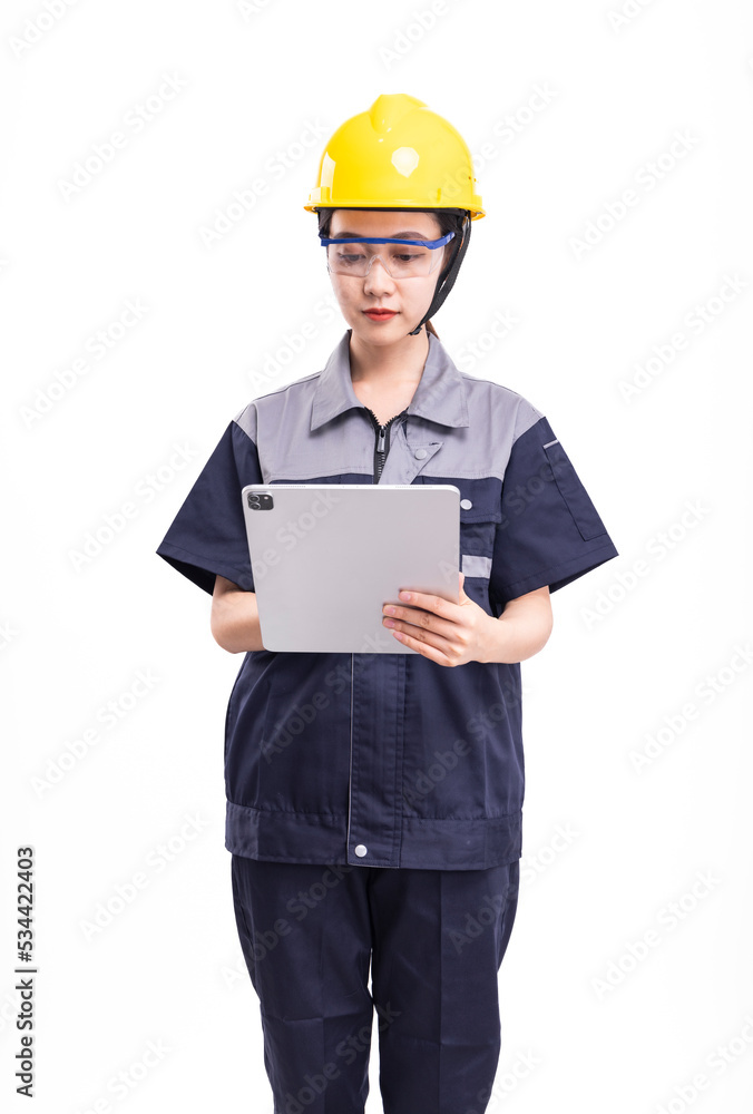 A female worker in a hard hat and uniform holding a computer