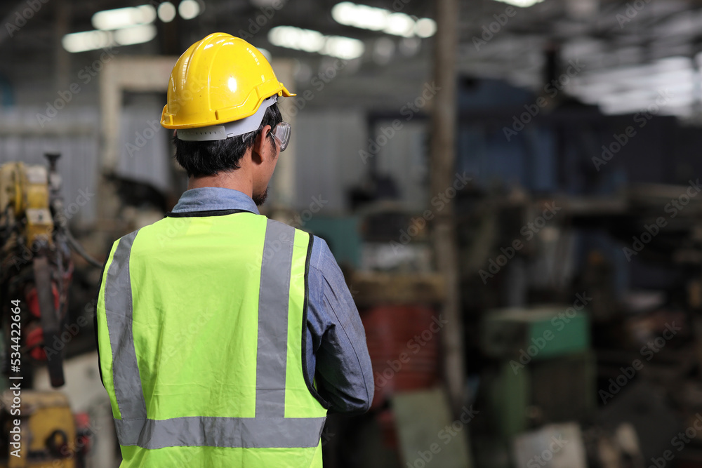Rear view confident technician engineer and worker in protective uniform standing and looking away while controlling operation checking industry machine process at industry manufacturing Rear view confident technician engineer and worker in protective uniform standing and looking away while controlling operation checking industry machine process at industry manufacturing